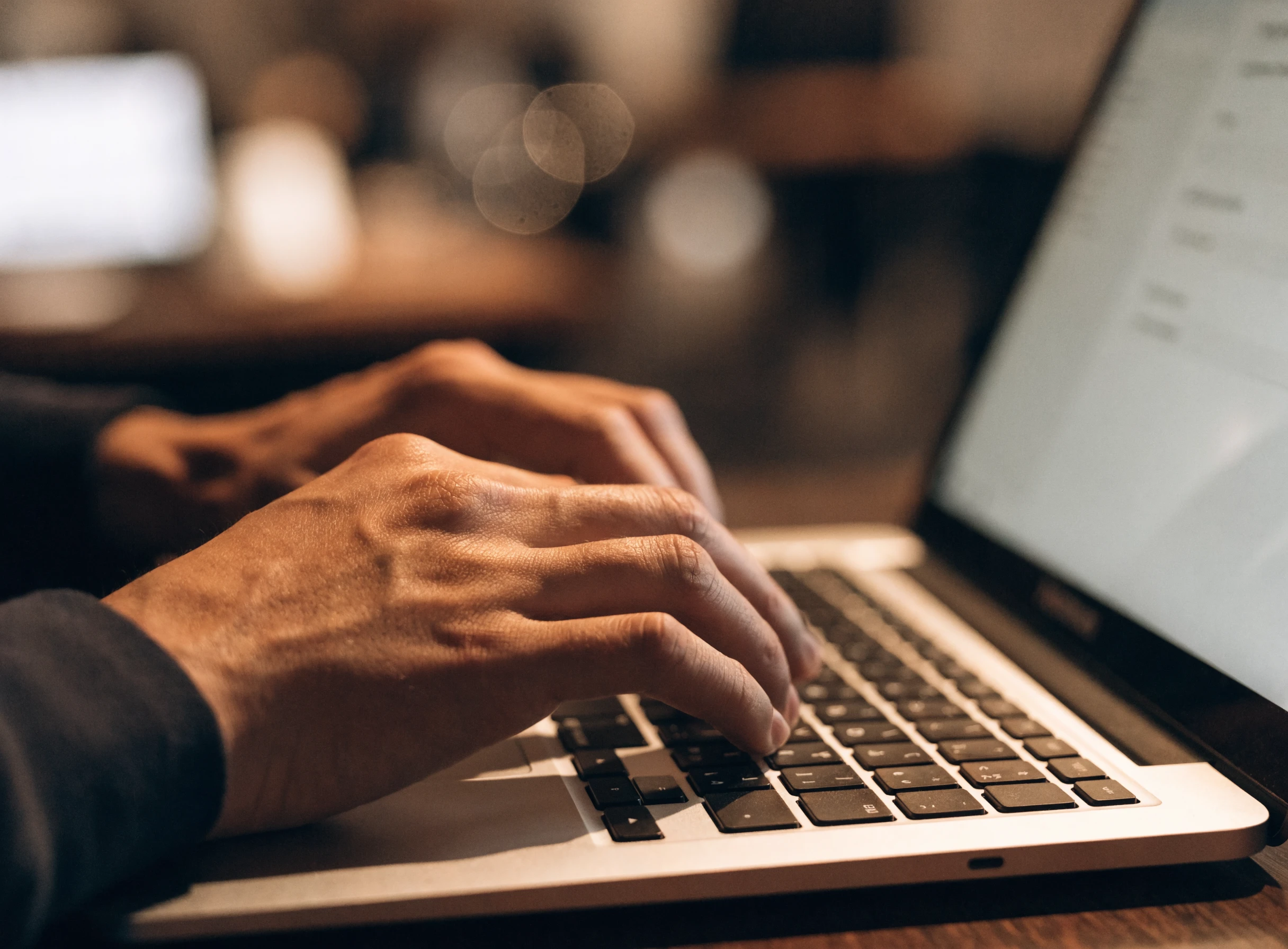 Tangan menaip pada laptop dengan borang dalam talian di skrin