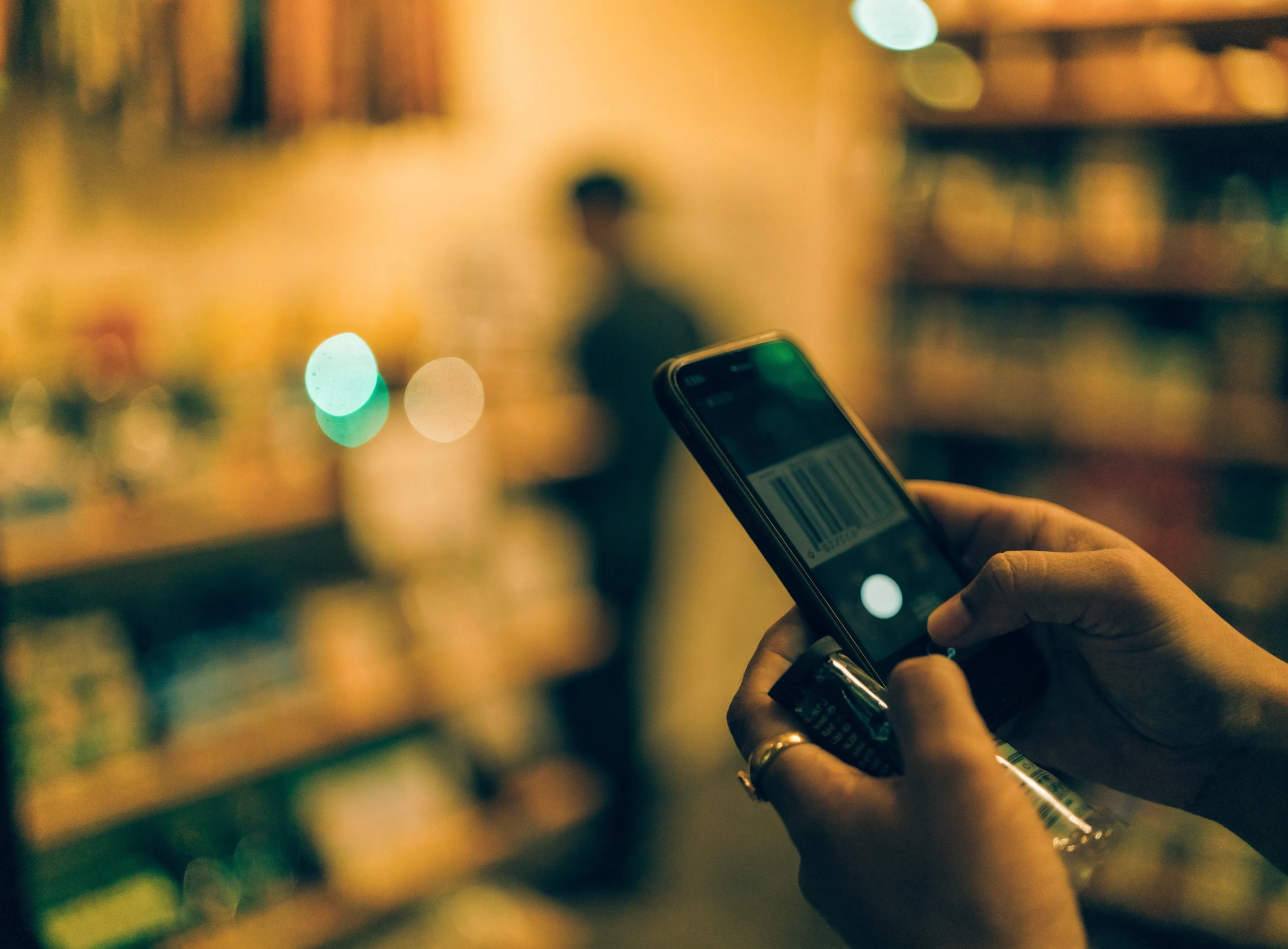 Kamera telefon mengimbas barcode produk di kedai runcit