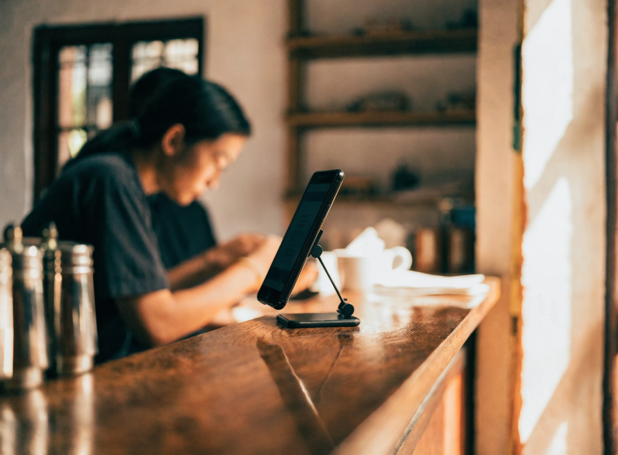 Telefon di atas dudukan digunakan sebagai POS di kaunter kafe