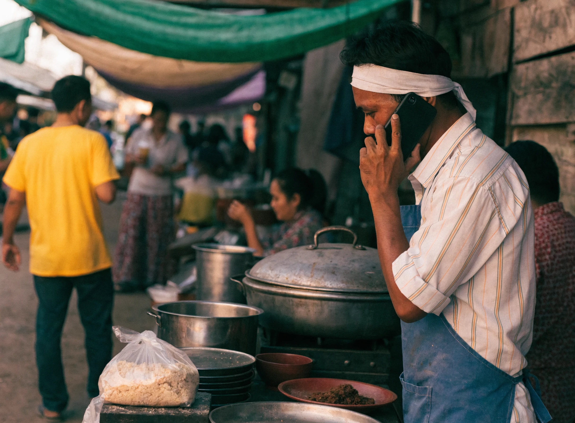 Peniaga bazaar mengambil pesanan menggunakan telefon