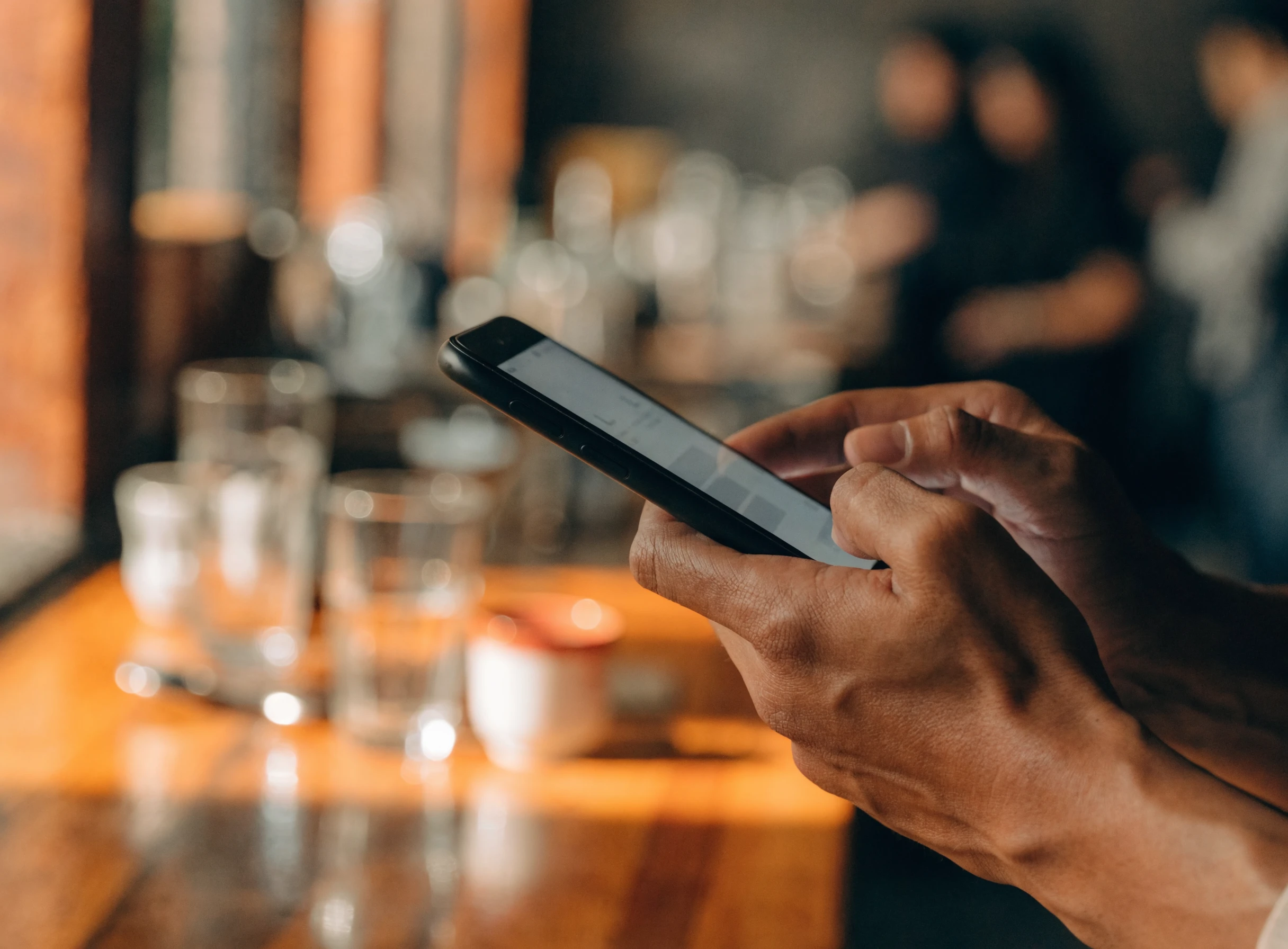Peniaga menggunakan telefon sebagai POS di kaunter kopitiam