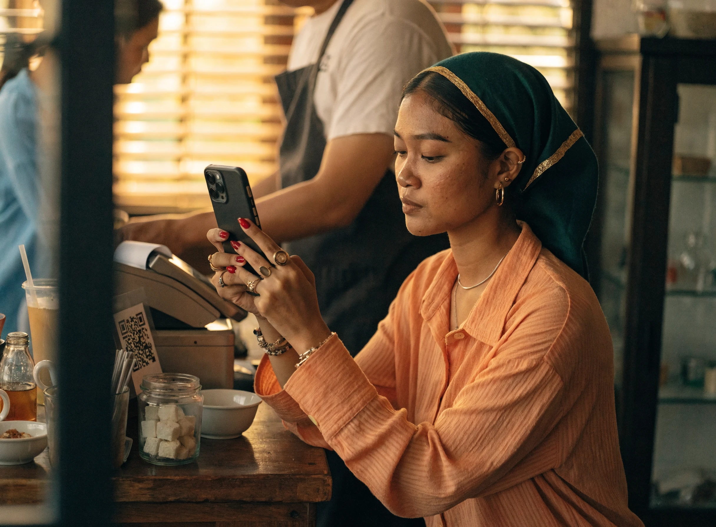 Pelanggan mengimbas kod QR untuk membayar di kaunter kafe kecil