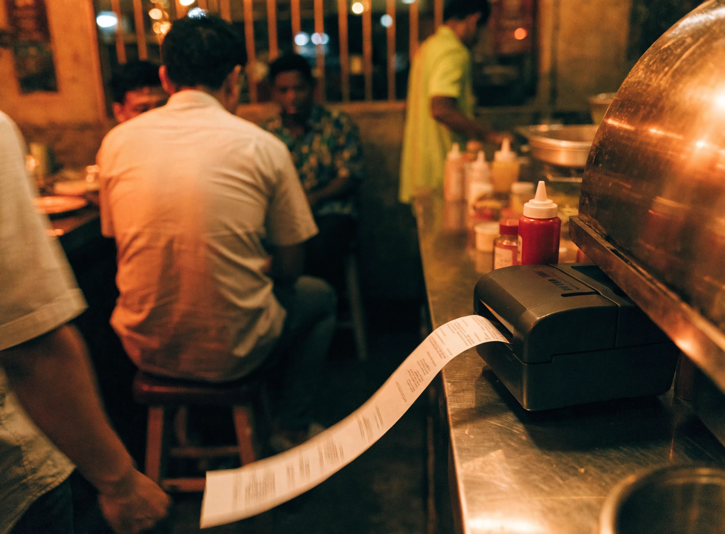Printer thermal mencetak resit di kaunter restoran mamak yang sibuk