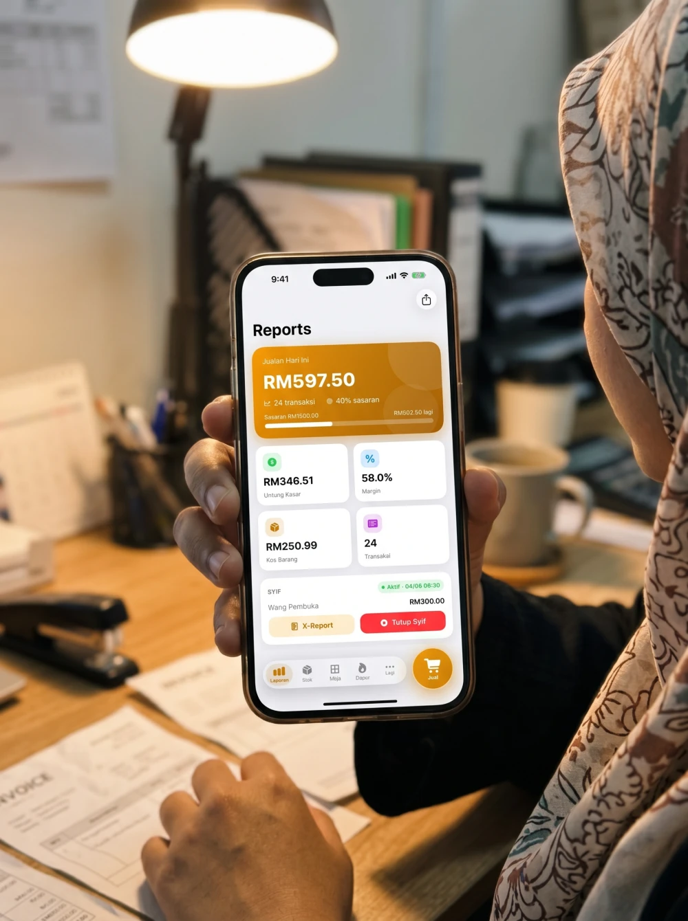 Skrin Laporan Pitis sebenar pada iPhone dipegang pemilik perniagaan